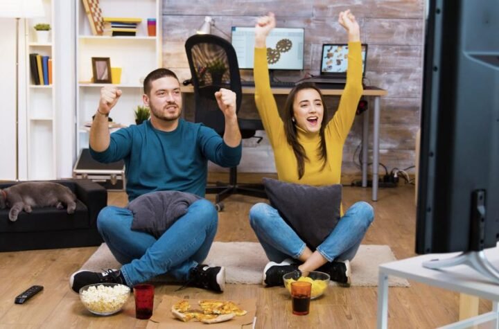 a couple sitting together and watching tv