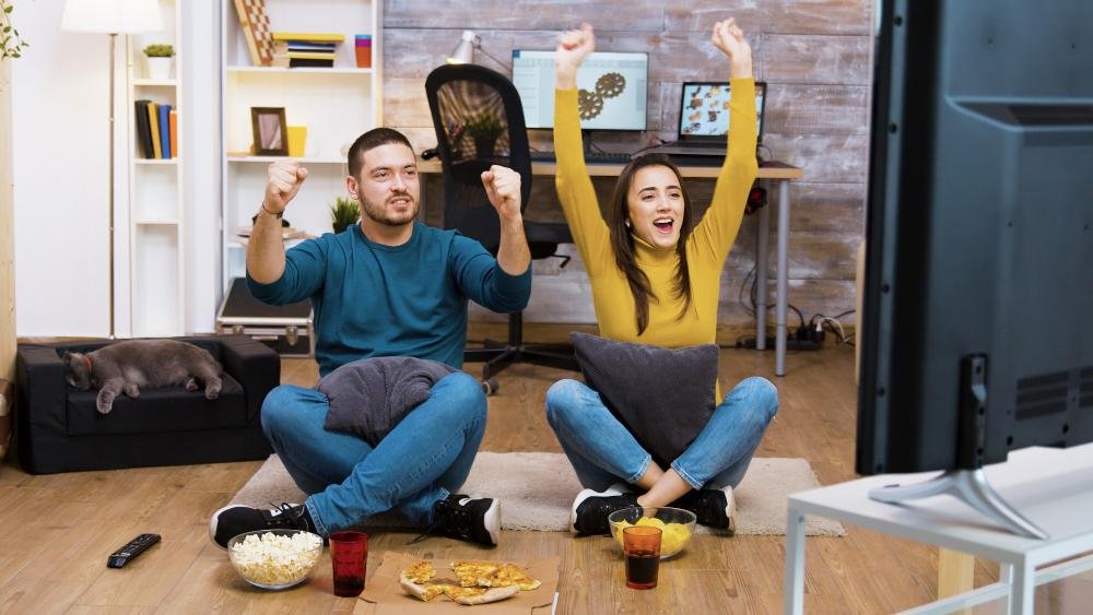 a couple sitting together and watching tv